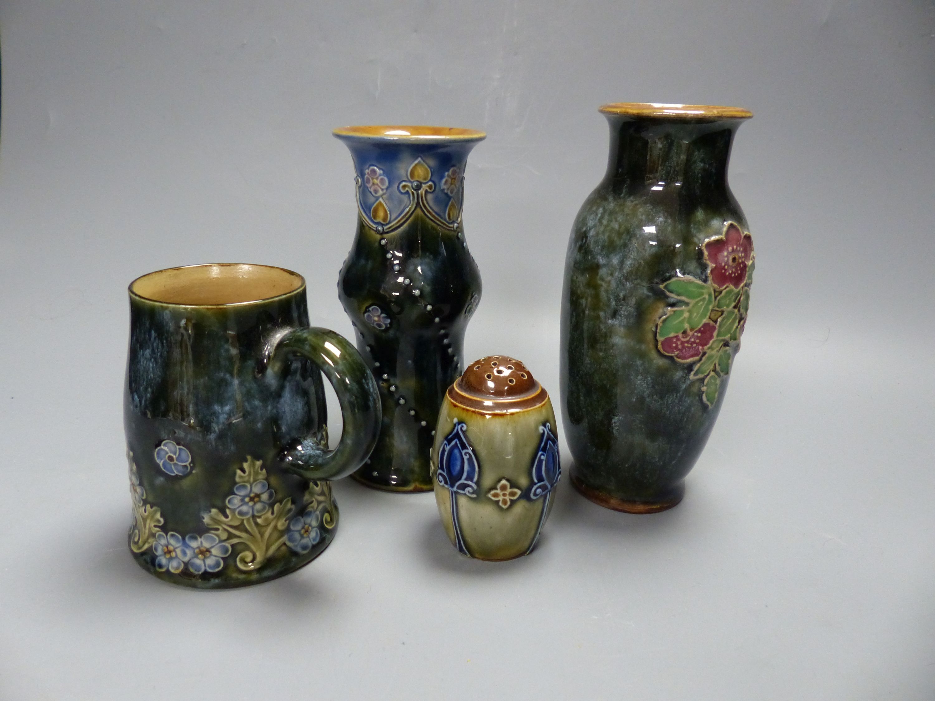 Four pieces of Royal Doulton stoneware including two vases, a mug and a pepperette, tallest 16cm